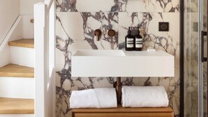 A bathroom with a marble backsplash, a wooden vanity, a mirror, and a glass shower enclosure. - Maison Legendre - Luxury Townhouse with 5BDR & AC in Batignolles (Paris)
