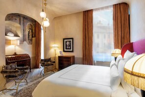 A hotel room with a large bed, a wooden chest, a desk, and a chair. - The James Suite Hotel Firenze 1564 - Small Luxury Hotels of the World (Florence)