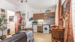 A compact living space with a kitchen, dining area, and a small seating area. - La Tanière du Cowboy (Orléans)