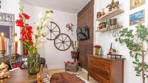 A cozy living room with a wooden coffee table, a leather sofa, a rustic rug, and a wooden dresser. - La Tanière du Cowboy (Orléans)