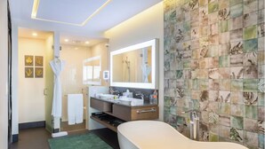 Un bagno moderno con una vasca freestanding, due lavandini e un ampio specchio.