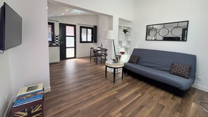Una sala moderna con un sofá, una mesa de comedor y un televisor.