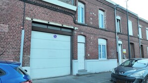 Rivissä on tiilitaloja, joissa on valkoiset autotallin ovet, katulamppu ja parkkeerattuja autoja.