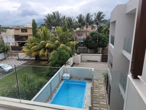Enjoy a refreshing swim in the pool surrounded by lush greenery.