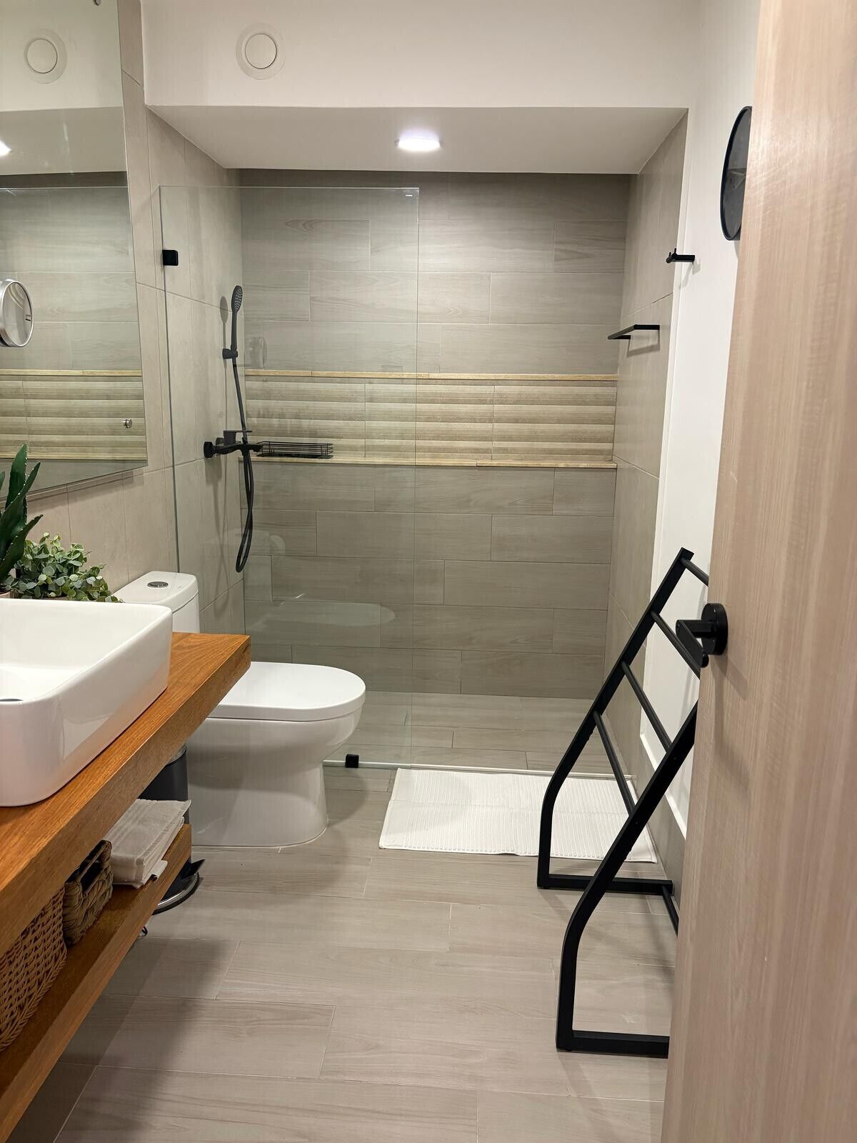 A modern bathroom with a toilet, sink, and shower area.