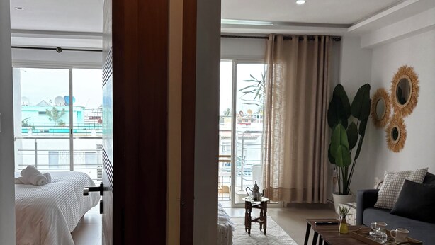 Een hotelkamer met een bed, een slaapbank, een bijzettafeltje en uitzicht op het omliggende landschap.
