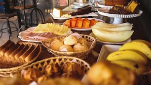 A buffet with various food items including sliced meats, cheeses, fruits, and pastries. - Pousada & Restaurante Praeros LTDA (Rifaina)