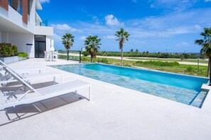 A modern pool area with lounge chairs and a clear view of the surrounding landscape.