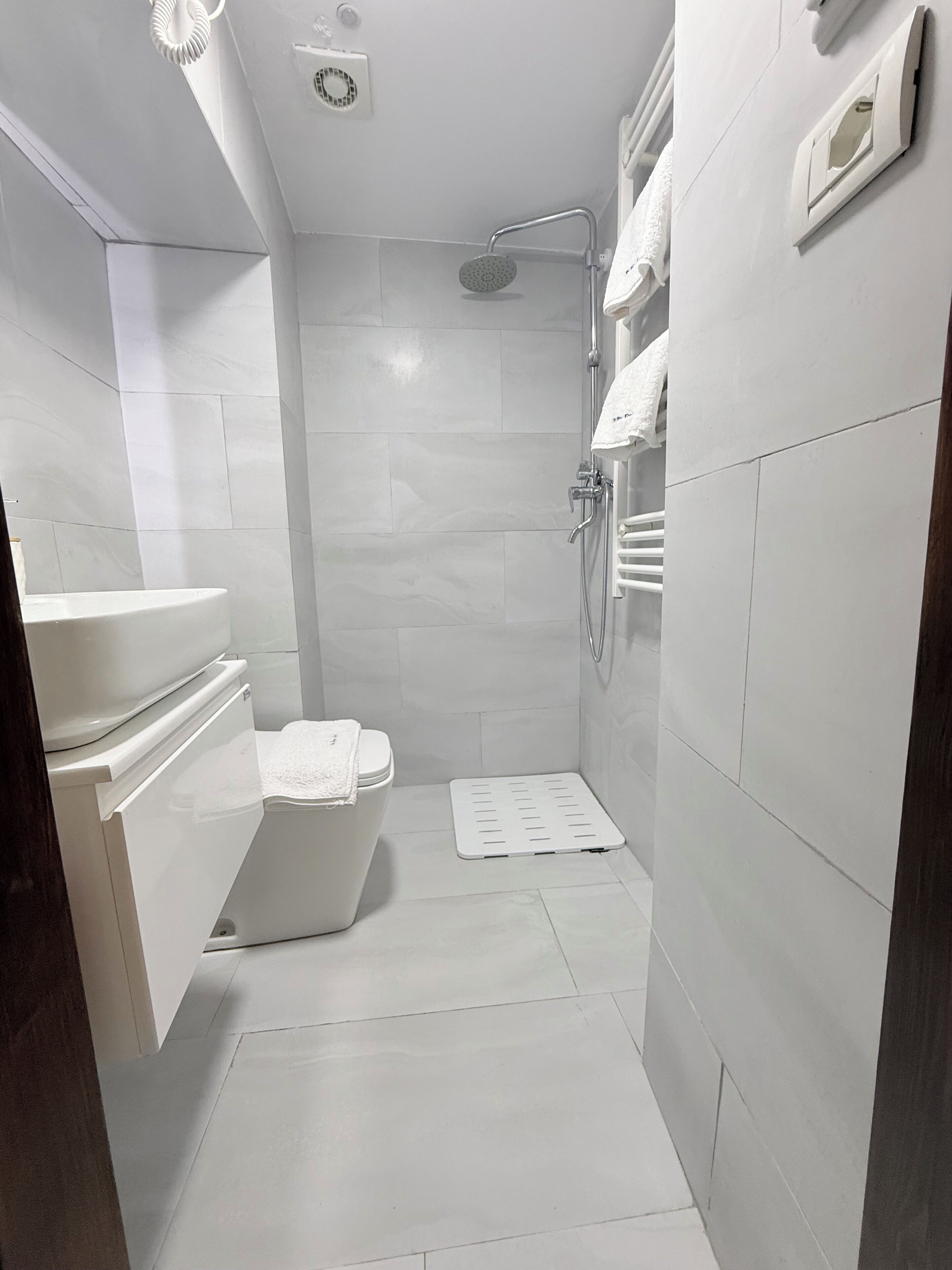 Un baño moderno con inodoro, ducha y barra para toallas.