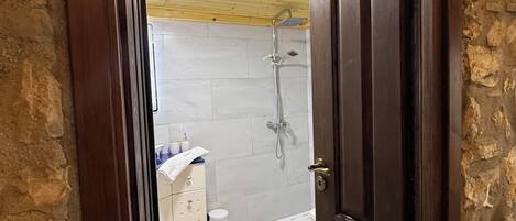 A bathroom with a shower, a toilet, and a sink.