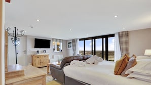 Habitación de hotel con cama, escritorio, silla, televisión y vistas del paisaje.