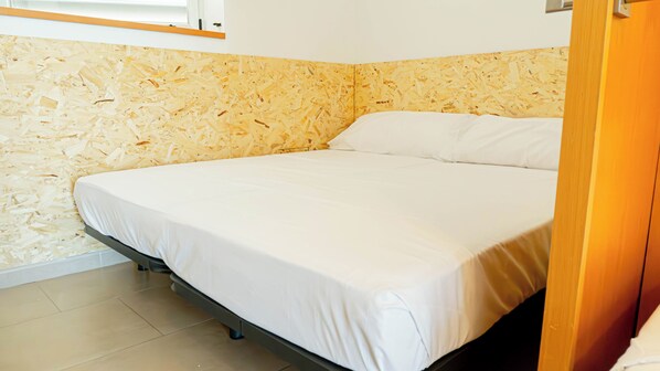Une chambre à coucher avec un lit, un mur en bois et une fenêtre.