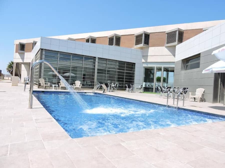 Una piscina al aire libre de temporada, sombrillas