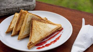 A plate with three triangular sandwiches and a white napkin on a wooden table.