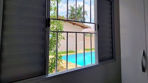 Una ventana con vista a una piscina y una casa.