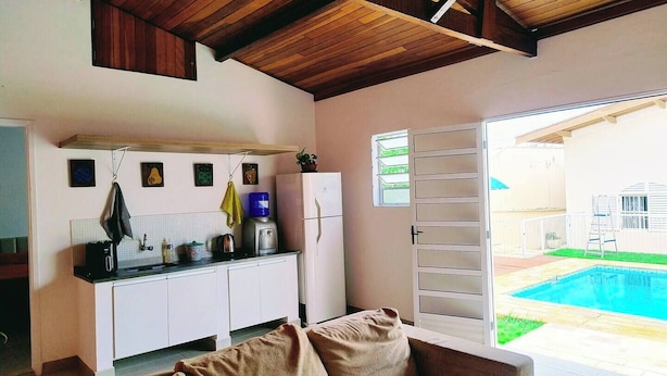 Un espacio habitable compacto con kitchenette, un sofá y vista a una piscina.
