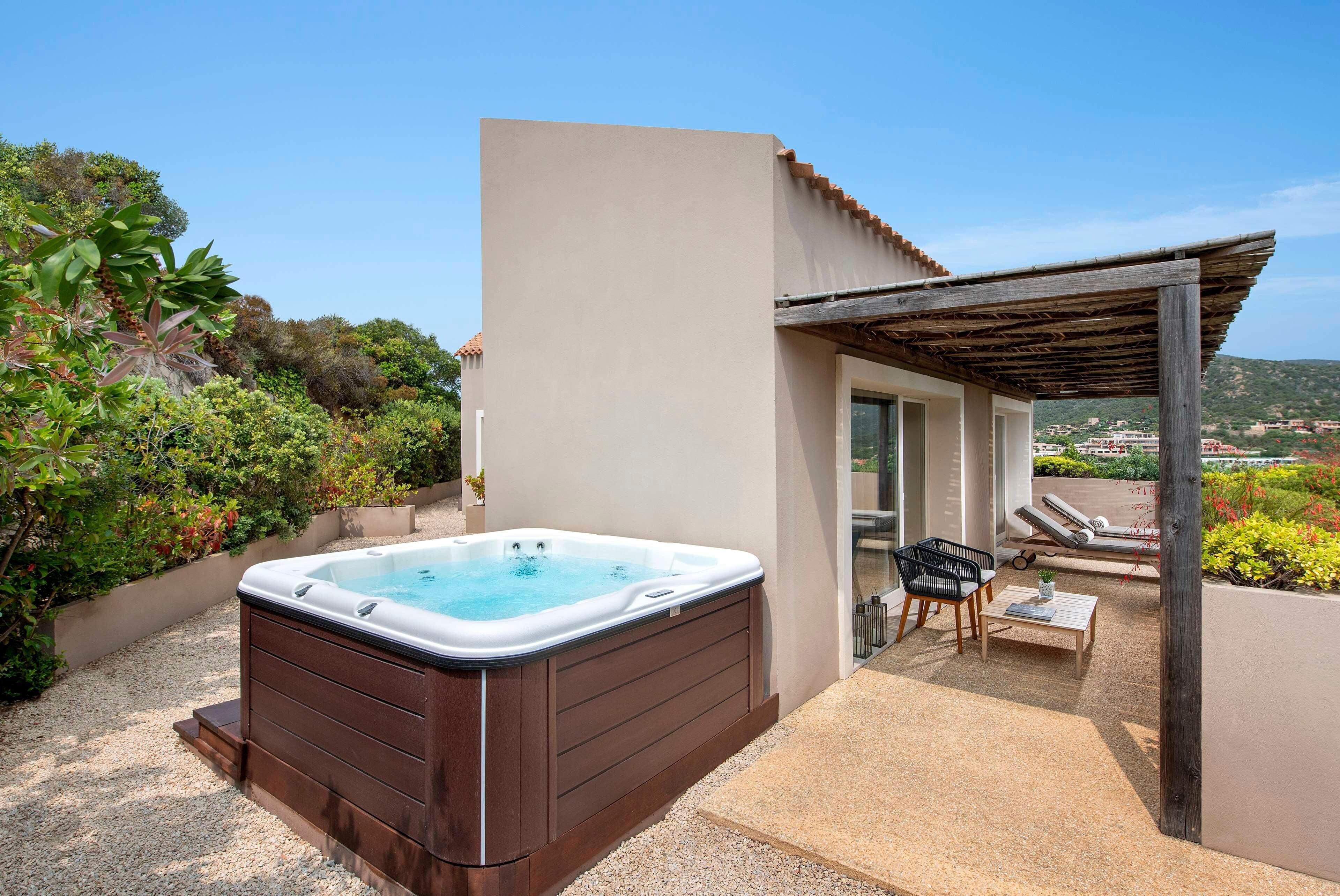 A hot tub in a covered outdoor area with a view of the landscape.