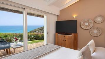 Une chambre d’hôtel avec un lit, une télévision et une vue sur l’océan.