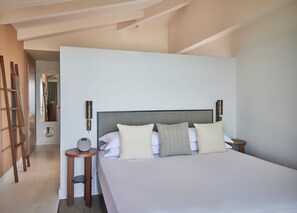 Un dormitorio moderno con una cama grande, una mesita de noche y una lámpara de pared.