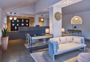 Een moderne woonkamer met een bank, een bureau en een boekenkast.