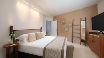 Un dormitorio moderno con una cama grande, mesitas de noche, un televisor y un armario.