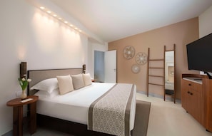 Un dormitorio moderno con una cama grande, mesitas de noche, un televisor y un armario.