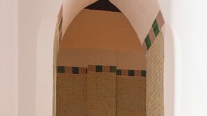 A bathroom with a tiled shower area, a sink, and a mirror.