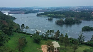 A river with a small building on a grassy bank.