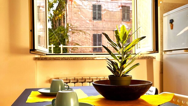 A dining table with a plant, two cups, and a bowl. - Apartment in the center of Serravalle at 5min from the outlet Serravalle Mcarthurglen (Serravalle Scrivia)