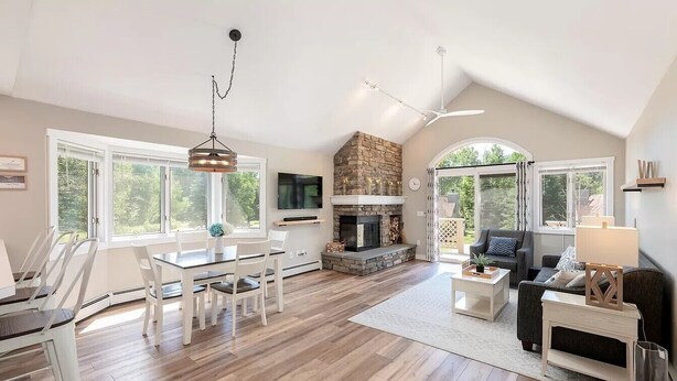 A spacious living room with a fireplace, dining area, and seating.