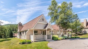 A two-story house with a gabled roof, a front porch, and a landscaped yard.