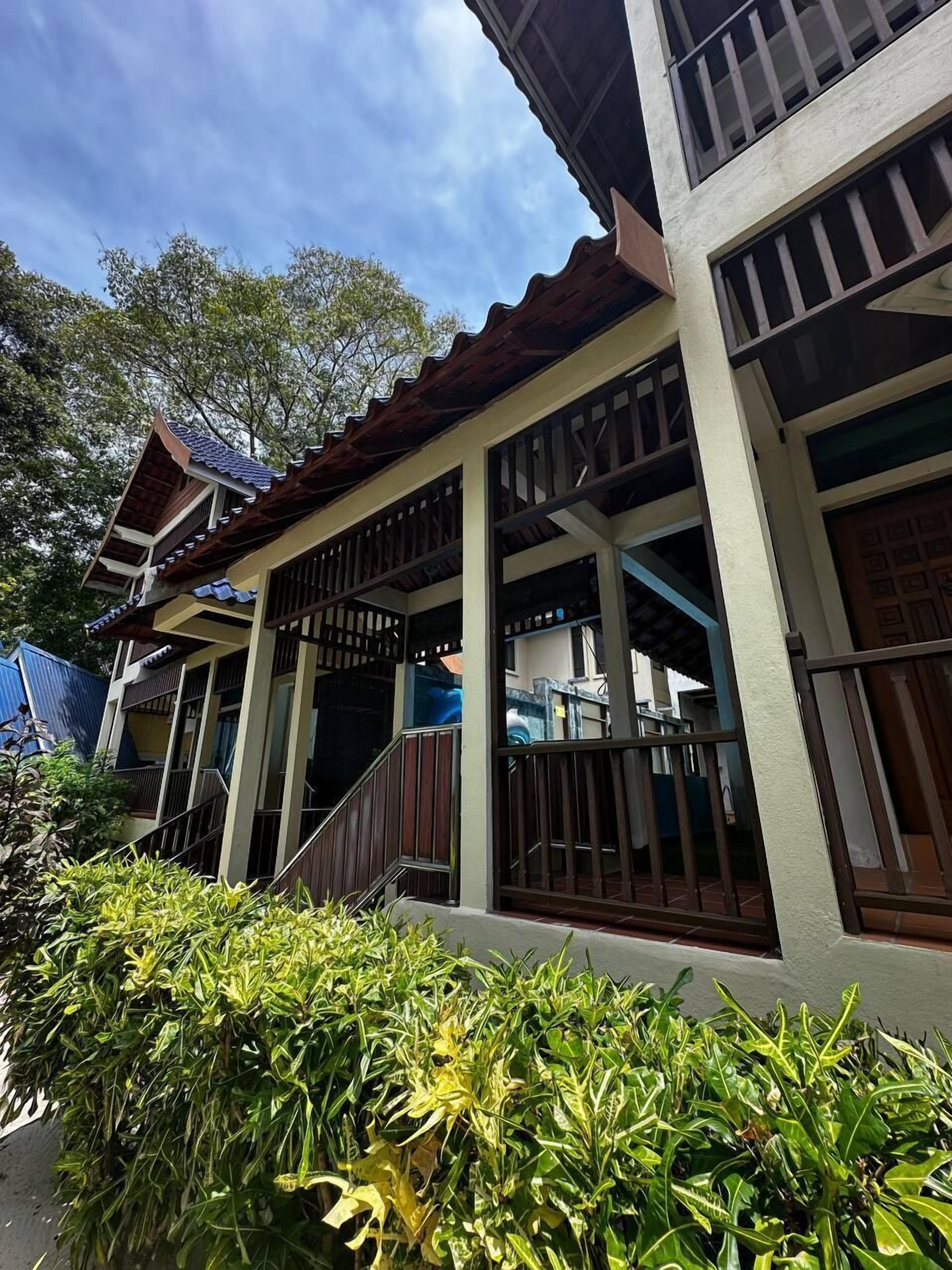 A traditional building with a tiled roof, large windows, and a covered porch area.