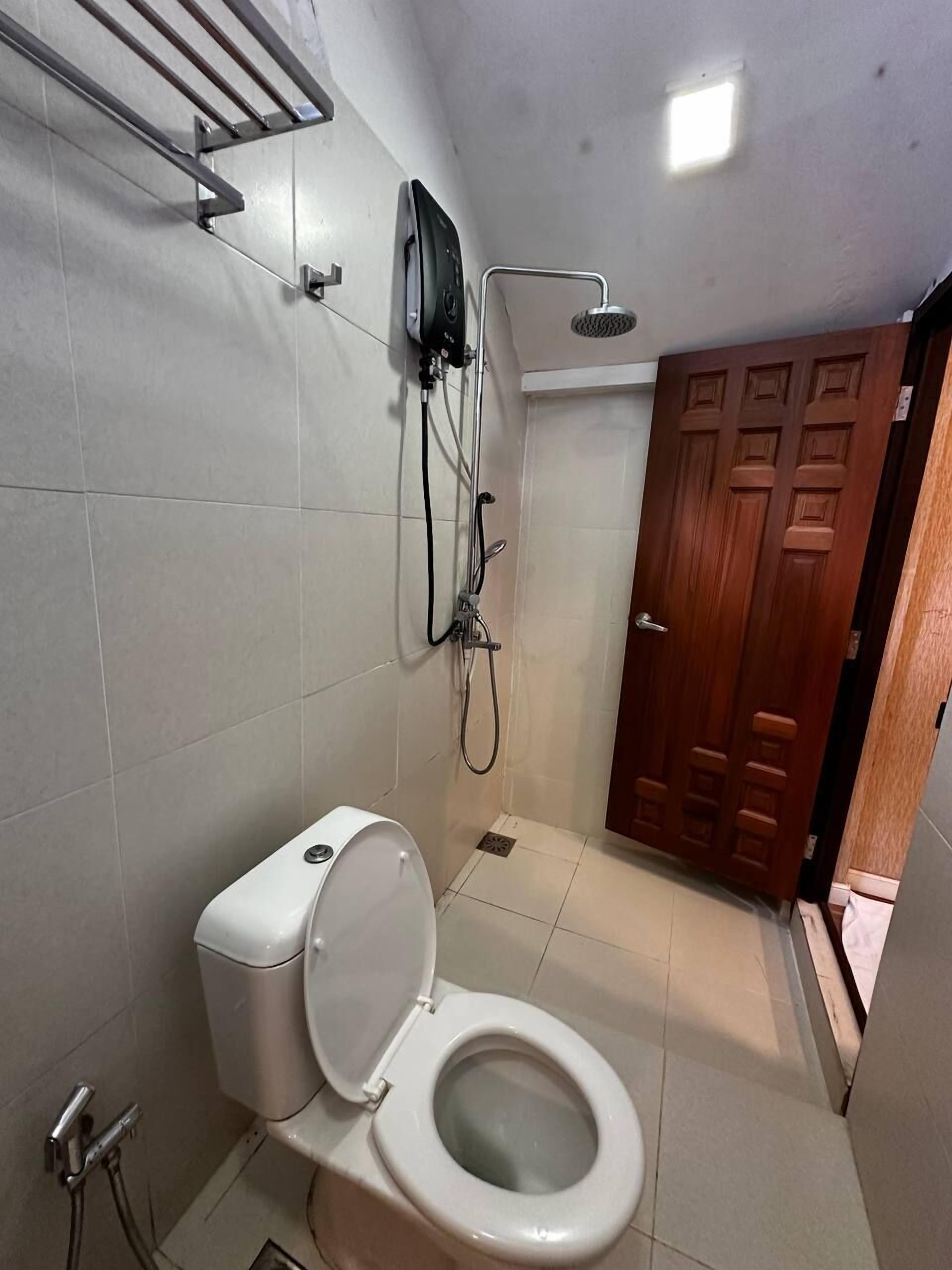 Un bagno piccolo con il water, una doccia e una porta in legno.