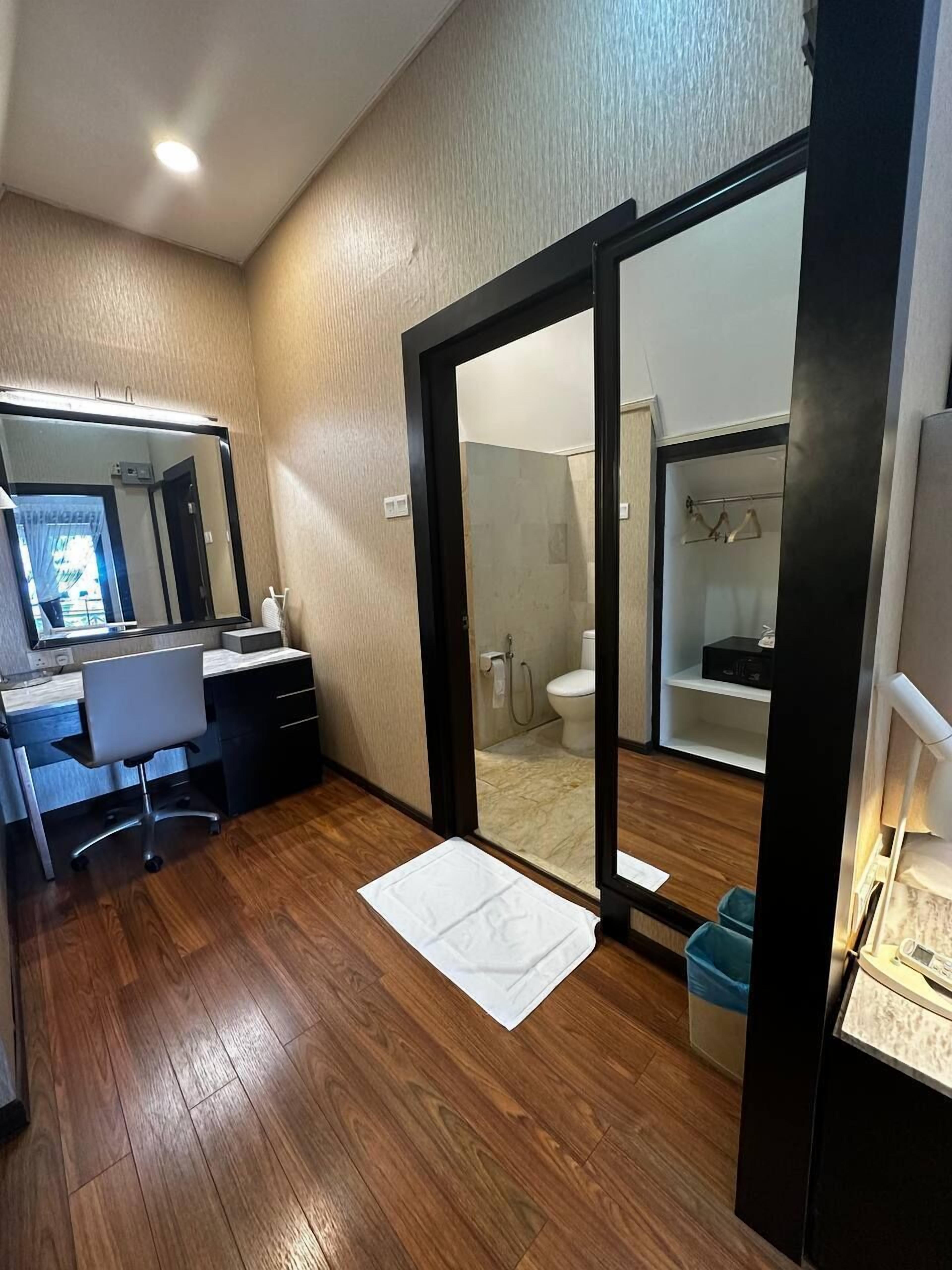 Une salle de bain moderne équipée d’une douche, de toilettes et d’un dressing ouvert avec des parois en verre.
