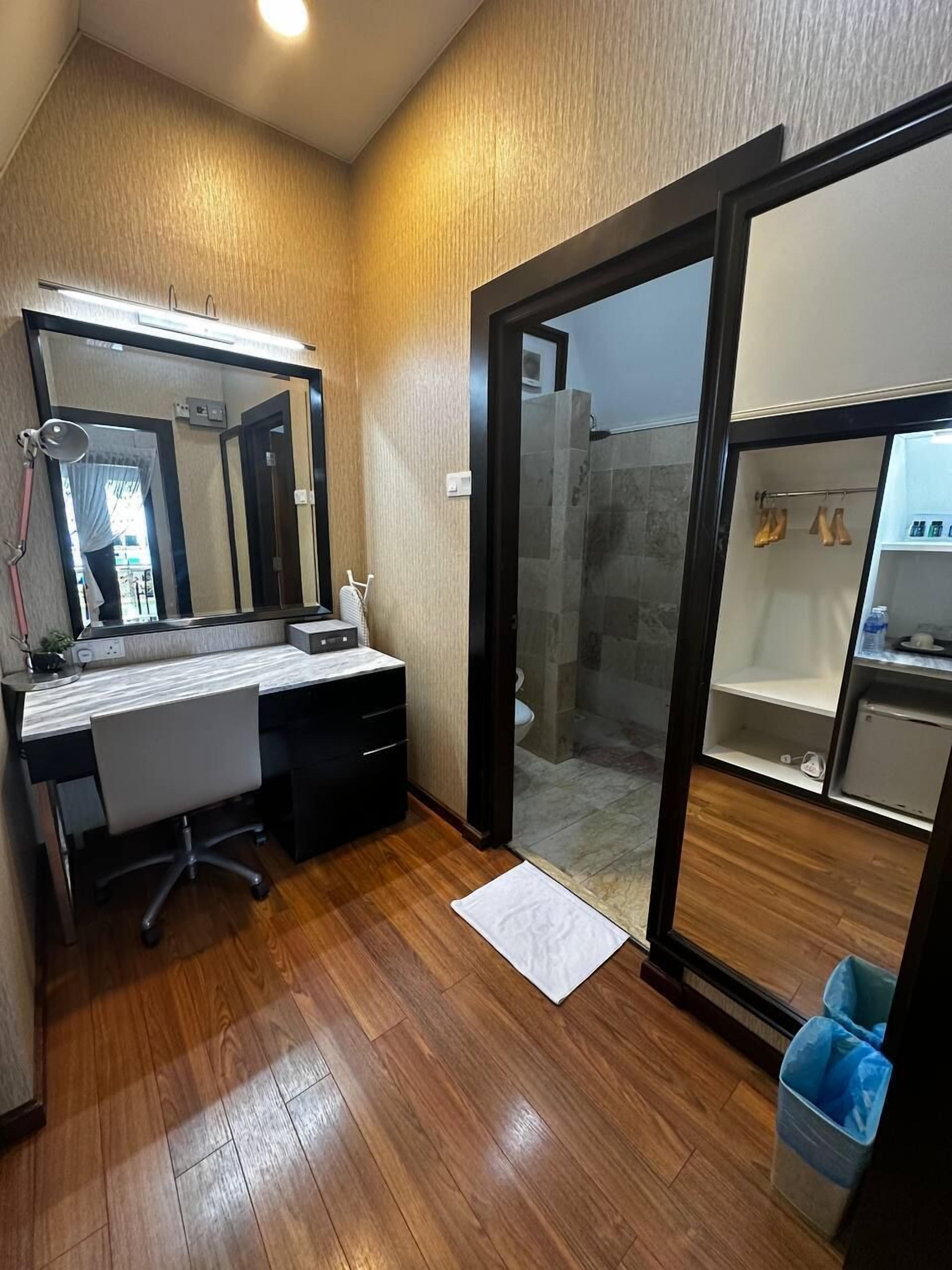 Une salle de bain moderne avec un meuble-lavabo en bois, un grand miroir et une cabine de douche en verre.