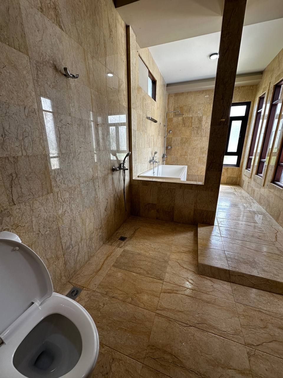 A bathroom with a toilet, a shower, and a sink.