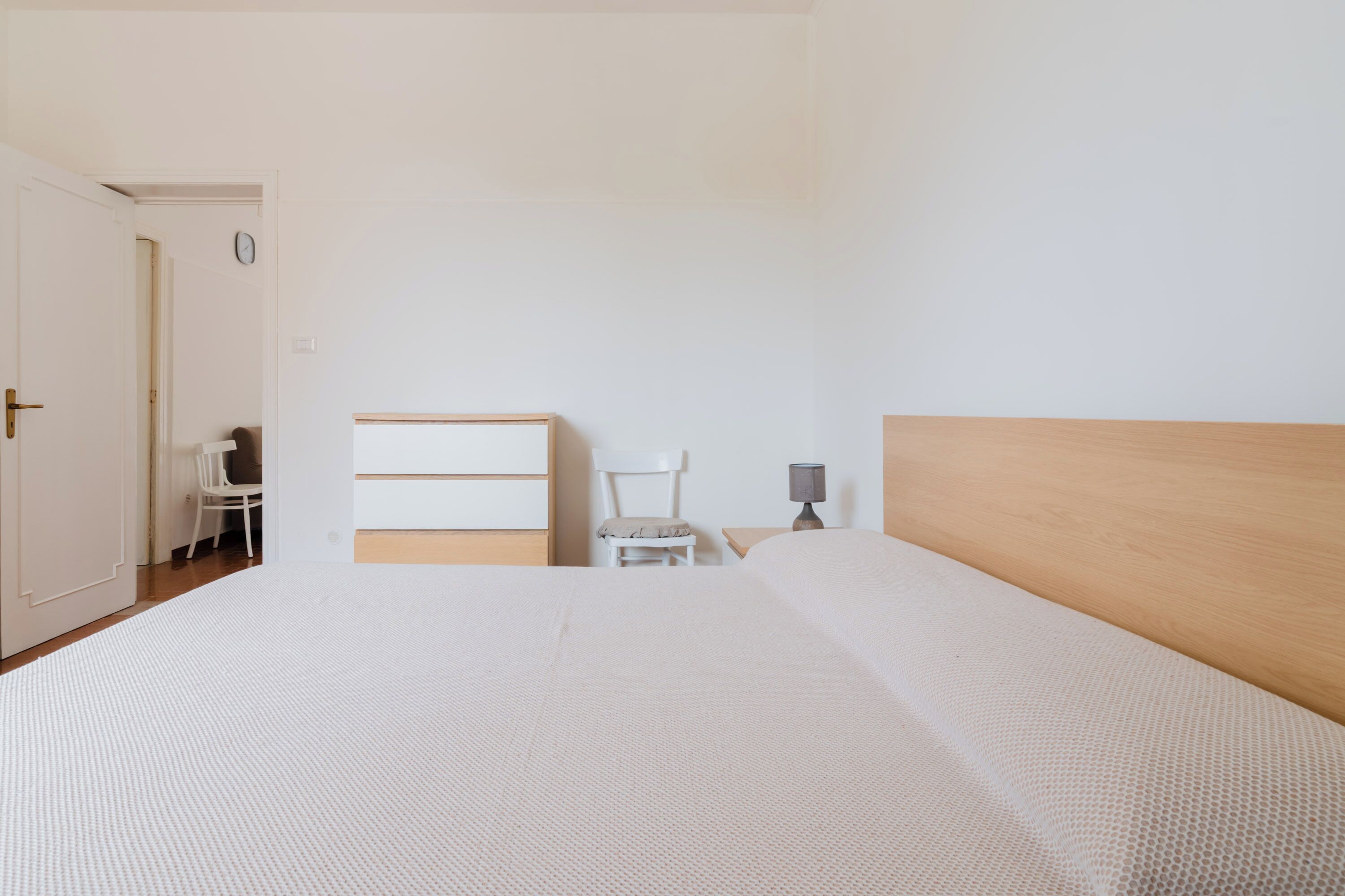 Une chambre à coucher avec un lit, une chaise, un bureau et une lampe.