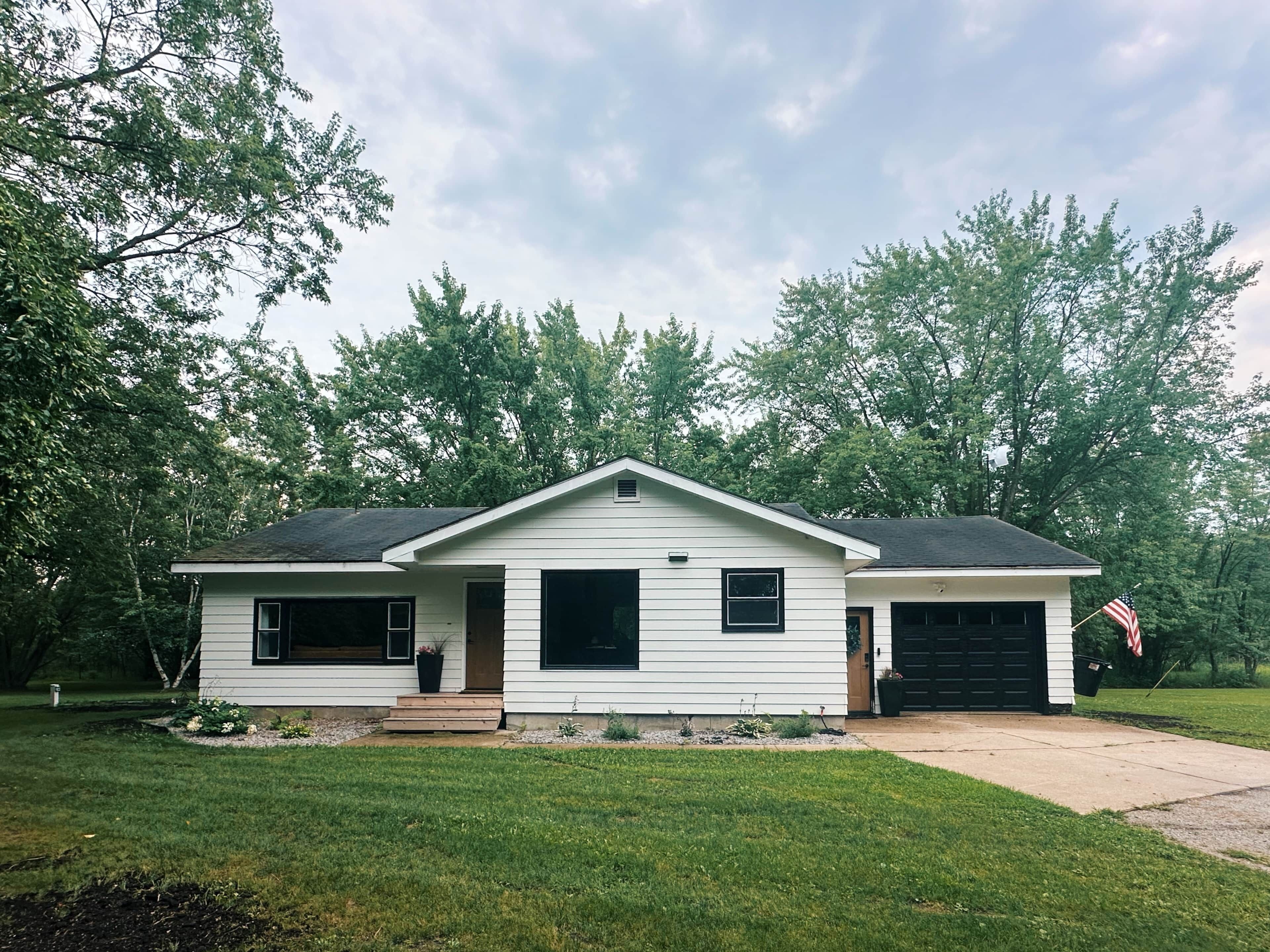 A single-story house with a garage, a front porch, and a small front yard.