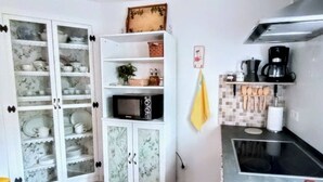Una cucina con forno a microonde, macchina del caffè e pensili con vetri.