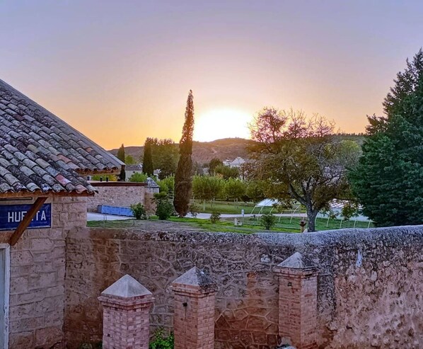 A stone wall with a sign reading "HUPETA" and a tiled roof structure.