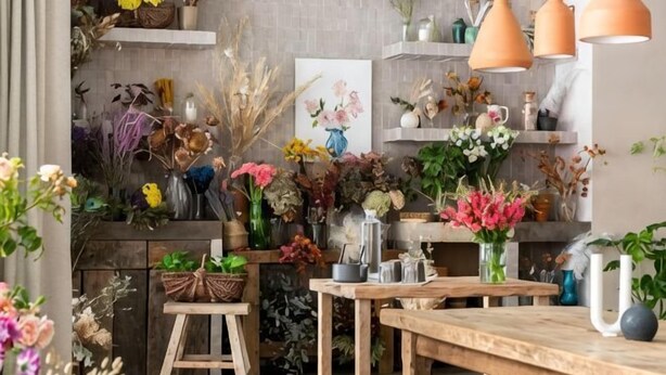 Una habitación con muebles de madera, estantes con diversos objetos y un cuadro en la pared.