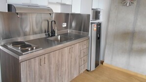 A modern kitchen with stainless steel appliances, wooden cabinets, and a built-in microwave.