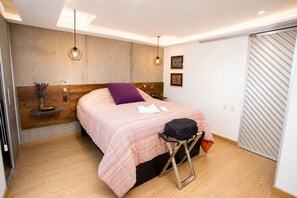 A modern bedroom with a bed, bedside table, and a wardrobe. - Luxury Laureles LA 70-Medellin Stunner (Medellín)