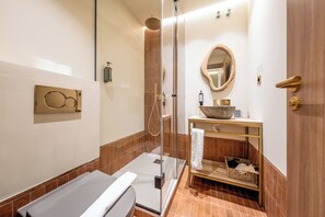 A modern bathroom with a glass-enclosed shower, a bathtub, a vanity with a large bowl sink, and a mirror with a wooden frame. - Hostal Ambos Mundos (Barcelona)