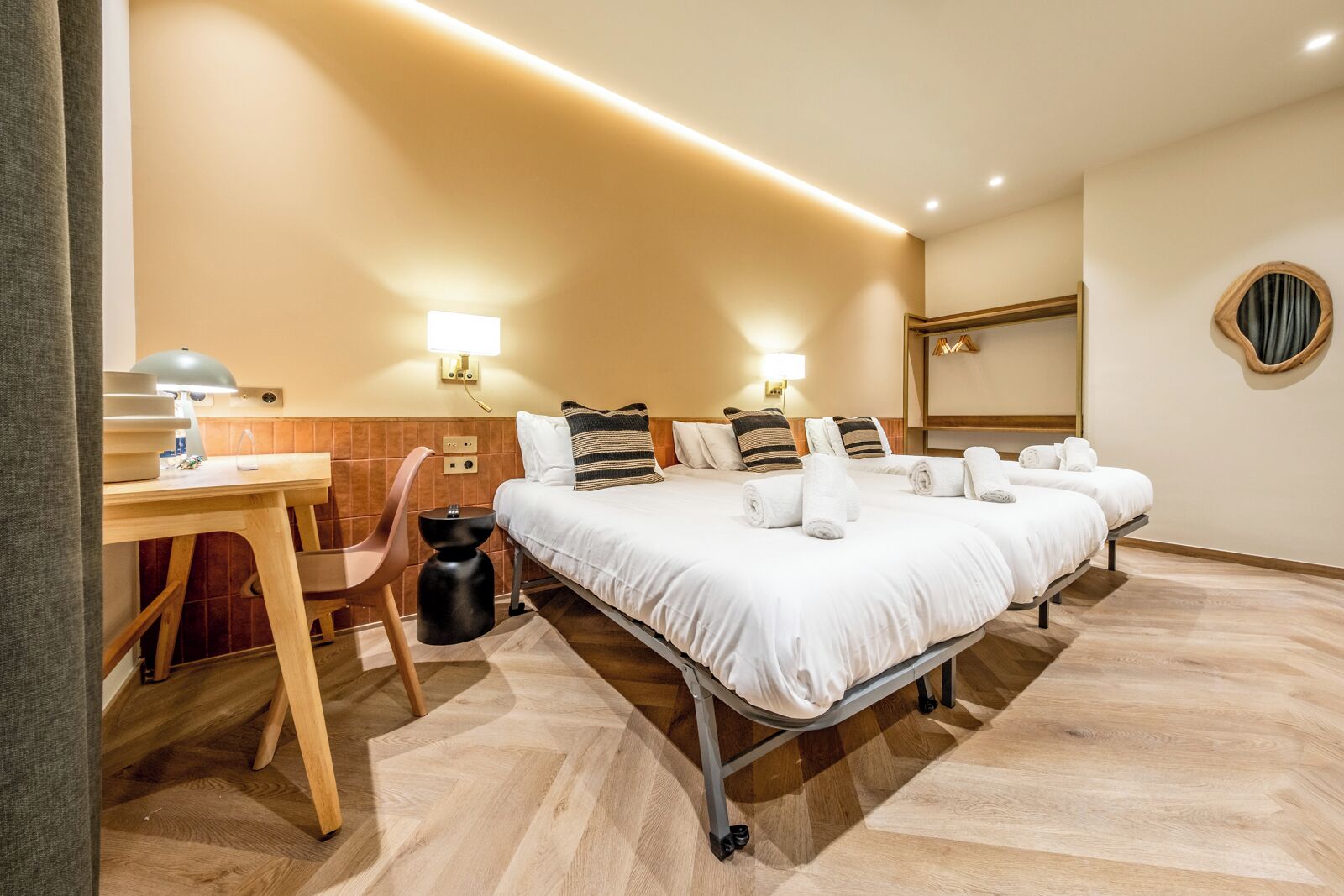 A hotel room with two beds, a desk, and a chair.