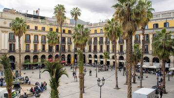 A courtyard with palm trees, outdoor seating, and a fountain.