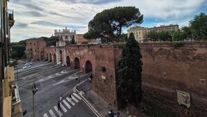 A historic stone bridge with arches, a large tree, and buildings in the background. - RESIDENZE SERVENTI LONGHI (Rome)