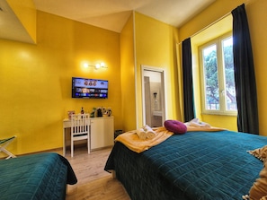 A hotel room with a bed, a desk, a chair, a TV, and a window with curtains. - RESIDENZE SERVENTI LONGHI (Rome)