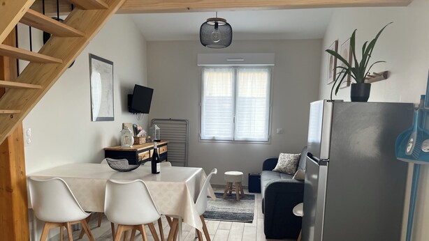 A compact kitchen with a dining table, chairs, a refrigerator, a sink, and a staircase. - Gîte Lucanna Apartment with terrace for 5 people (Unknown)