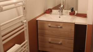 A bathroom with a white sink, wooden vanity, and a mirror. - Gîte Lucanna Apartment with terrace for 5 people (Unknown)